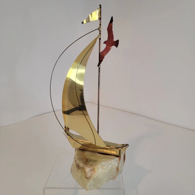 Add a touch of timeless nautical charm to your décor with this **Vintage Mid-Century Modern brass sailboat figurine**,...