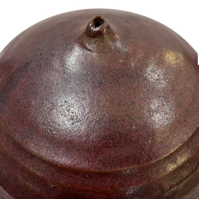 1980's hand-crafted studio stoneware pottery jar with distinctive "nipple" top opening. . The ridged body is glazed in a...