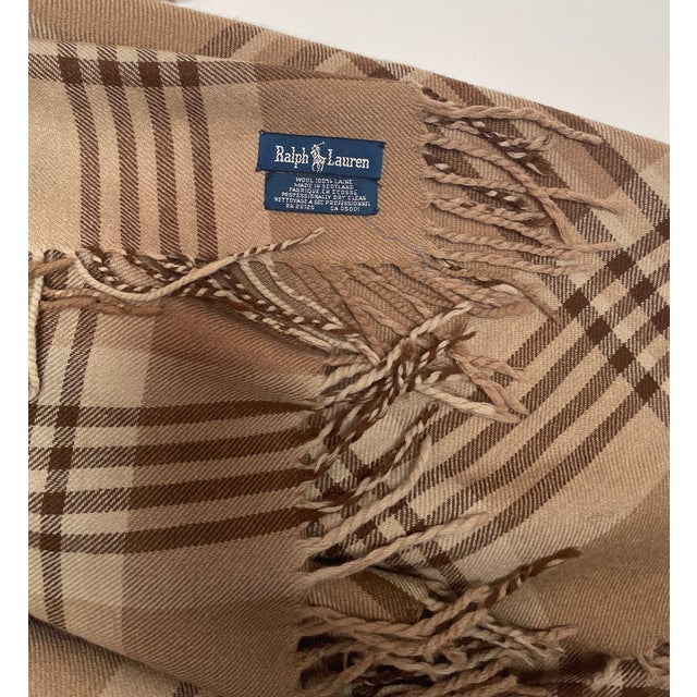 Woven in Scotland for Ralph Lauren, this beautiful neutral colored wool plaid throw with its hand-twisted 3” fringe can...