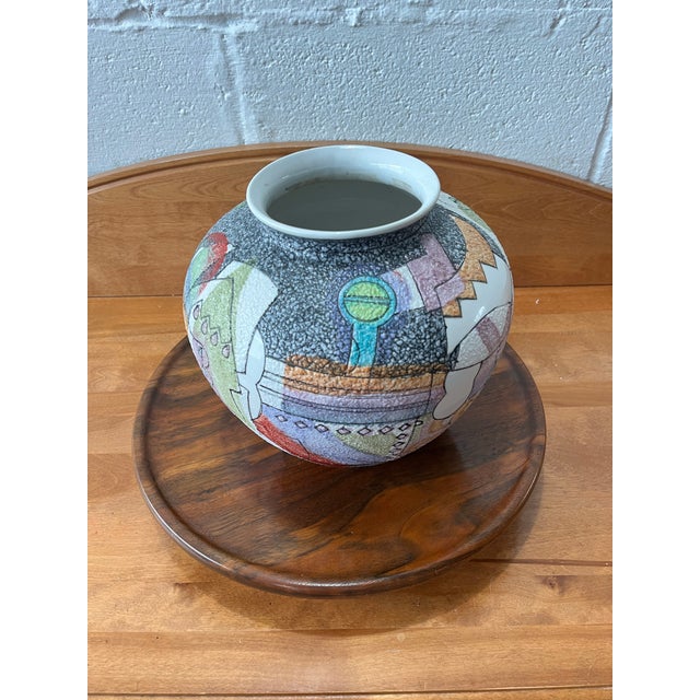 A striking postmodern studio pottery vase featuring a richly textured “fat lava” style glaze ground, overlaid with a...