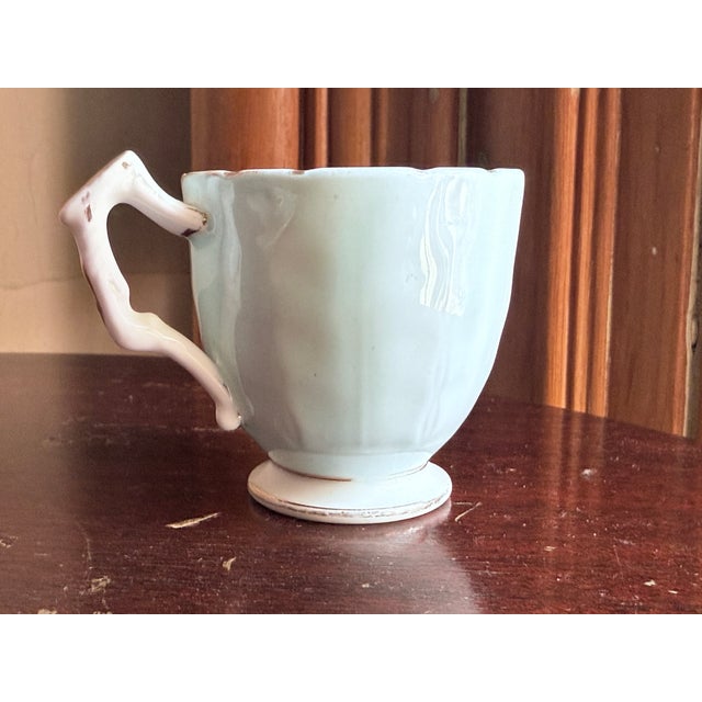 Aynsley English bone china demitasse cup and saucer. White porcelain base with hand-painted floral motif of pink rose...