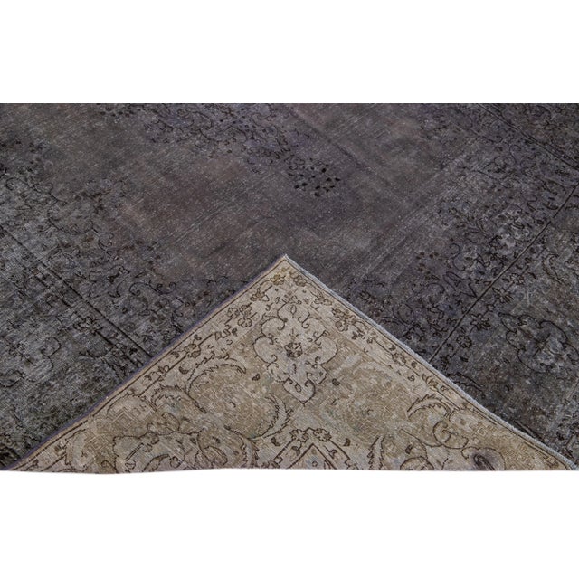 Beautiful Vintage Overdyed hand-knotted wool rug with a gray field. This Persian rug has black and brown accents in an...