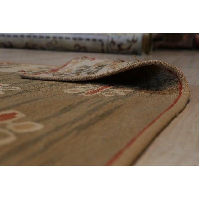 This green wool rug features a flat weave construction typical of Kilim style floor coverings. The primary green hue...