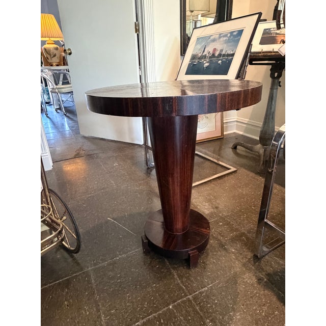 Sculptural Art Deco style side table crafted in richly figured mahogany with a dramatic tapered pedestal base and circular...