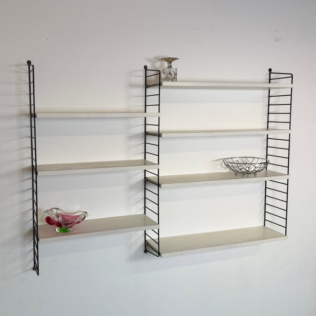 Modular wall rack from the 1960s by the renowned Swedish brand Nisse Strinning. The set consists of three black ladders,...