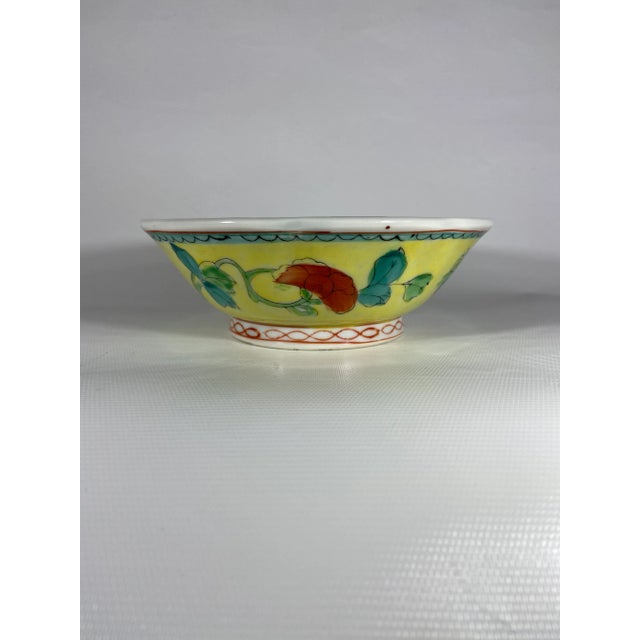 A beautiful round footed Chinese export famille jaune style porcelain bowl with yellow enamel ground and polychrome floral...