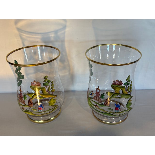 Offered for your consideration, this pair of hand painted hurricanes featuring Asian motifs with gilt trim on top edges...