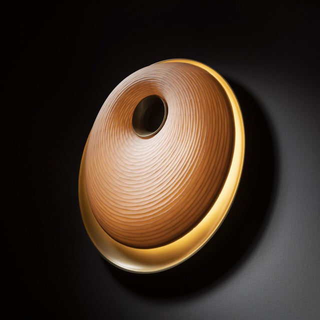 The Torus Sconce has a flawless design that calls to mind a beautiful shell shaped by water. The round diffuser is crafted...