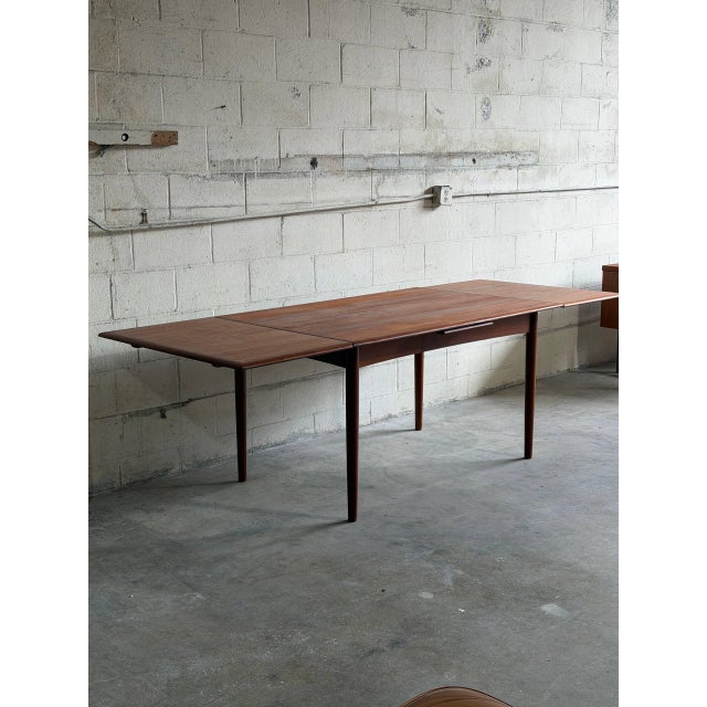 Beautiful vintage Scandinavian Modern extension dining table crafted in warm teak in Denmark. This elegant Mid-Century...