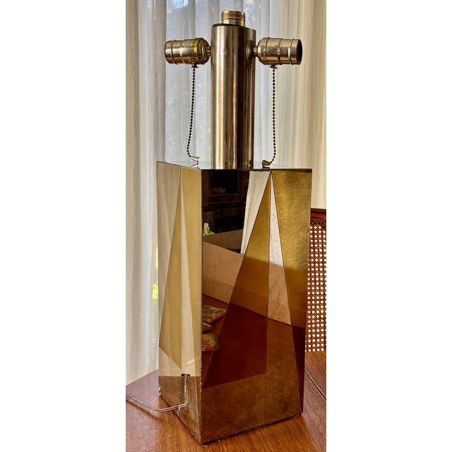 This striking lamp features geometric chrome and brass base. This lamp showcases a blend of Art Deco and Space Age...