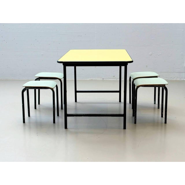 Charming swiss-made table set consisting of a rectangular metal table and four matching stackable stools. The tabletop...