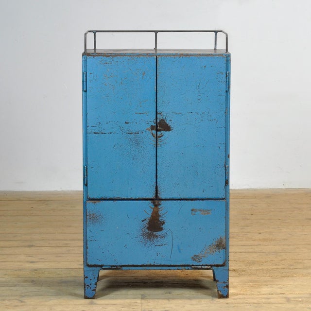 Bring a touch of vintage industry to your interior with this robust 1970s cabinet. Made of iron and finished in a blue hue...