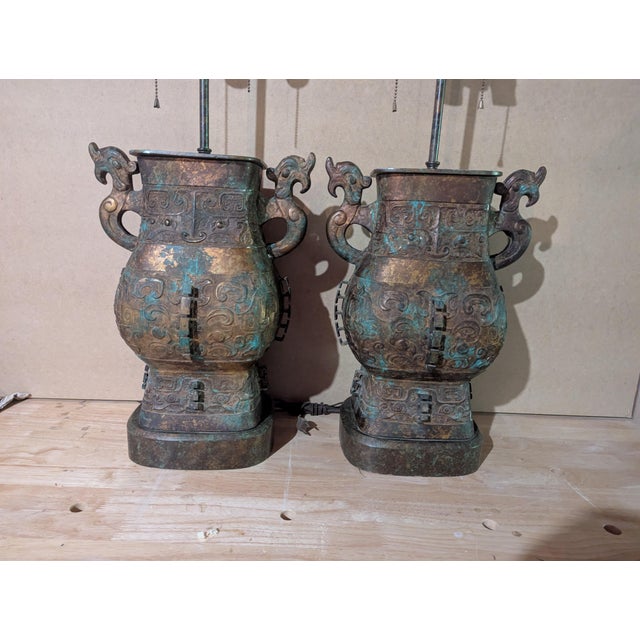 20th-century Warren Kessler table lamps fashioned from a patinated bronze archaistic Chinese vessel with dragon handles....