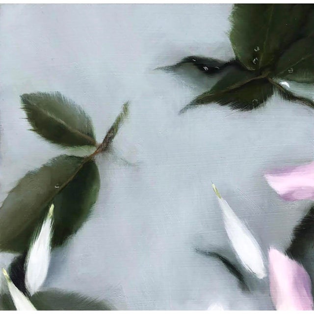 This oil on panel artwork presents a delicate arrangement of leaves and petals, suspended against a soft gray background....