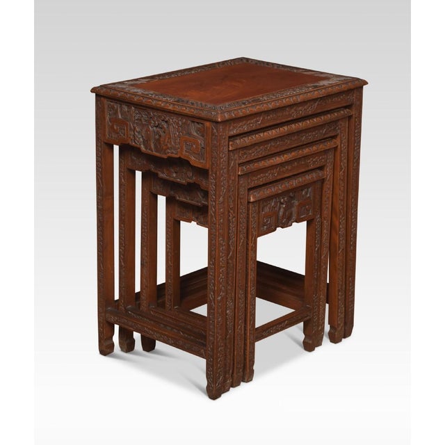 Nest of four Chinese rosewood tables each with a recessed rectangular paneled top and carved frieze on four slender...