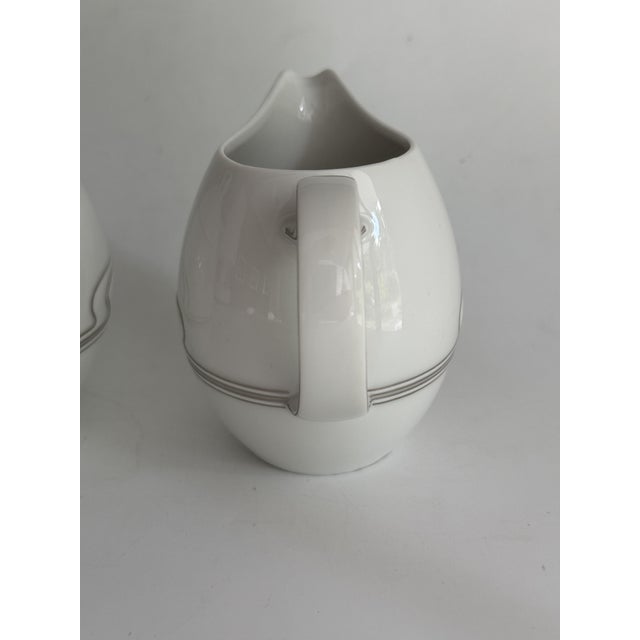 Item: Sugar bowl 0.3 L and creamer 0.27 L Manufacturer: Rosenthal Series: Asimmetria Decoration: White gold Material:...