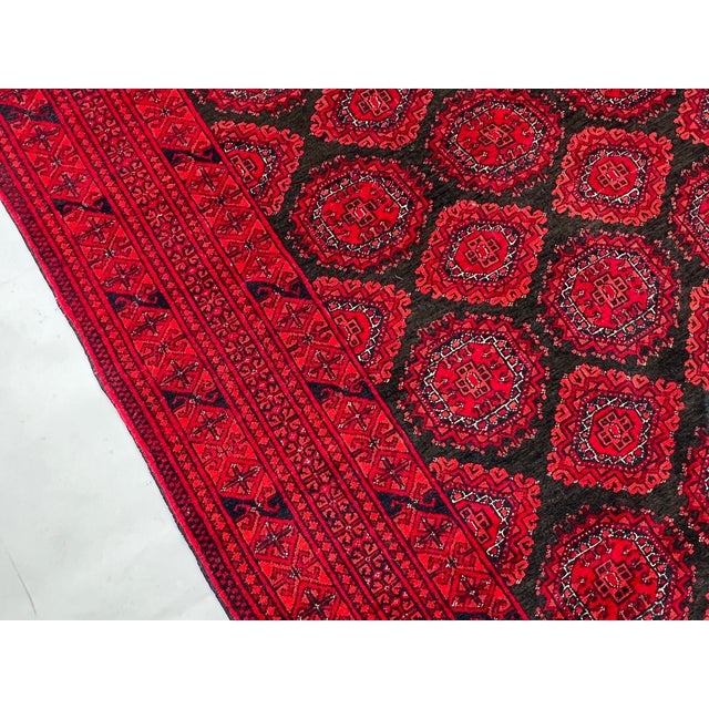 A vintage Afghan Ersari rug in the Turkmen Bokhara tradition — three columns of quartered octagonal güls locked into a...