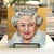Original Queen Elizabeth II portrait painting by Susan Howe, painted on an 8” square canvas with a luminous metallic gold...