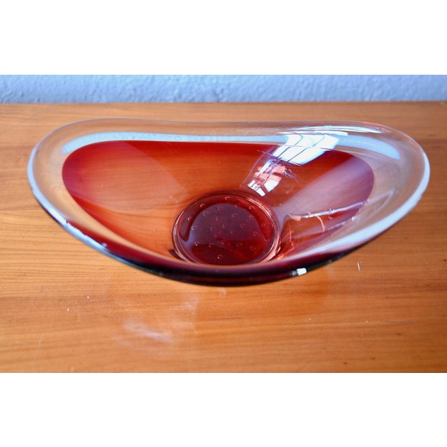 Designed by Paul Kedelv for Sölvehyttan, this bowl with its raised rim, crafted from cherry red and clear colored glass,...