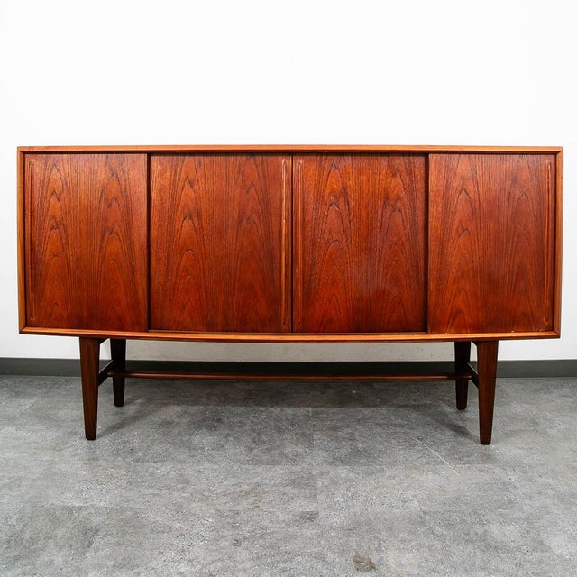 Restored Danish teak credenza with 4 sliding doors. This piece features a rosewood bar with a pull-out surface and fluted...