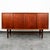 Restored Danish teak credenza with 4 sliding doors. This piece features a rosewood bar with a pull-out surface and fluted...