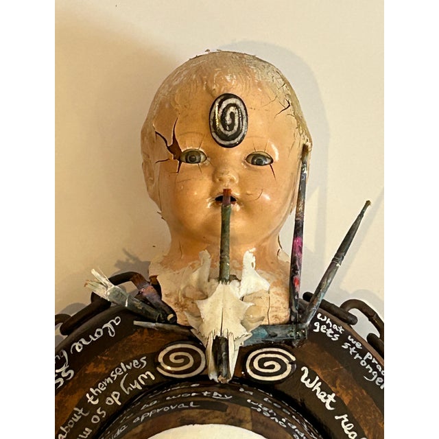 A powerful and personal mixed media wall sculpture titled “Spiraling” created on a wooden antique hat form. The stream of...