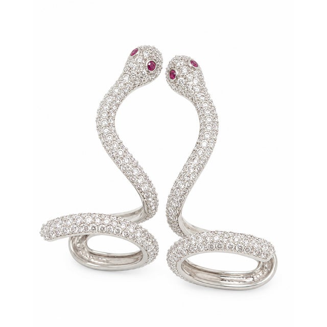Sculptural and unexpected, these 10K White Gold snake-inspired earrings are set with round natural diamonds in a flowing,...