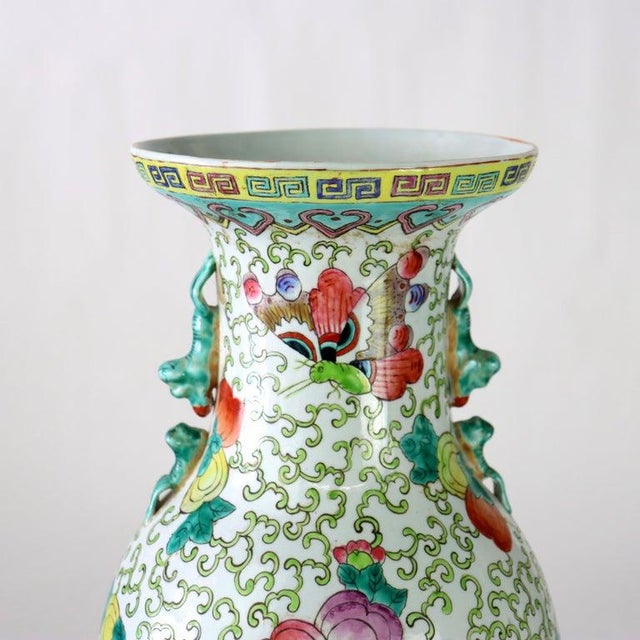 A Chinese Famille Rose porcelain vase from the 20th century, featuring intricate floral and vine patterns in vibrant...