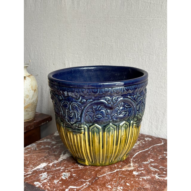 It has an intricate embossed design, showcasing a pattern of alternating roses and satyrs faces.