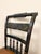 Classic Hitchcock chair featuring a deep black finish with traditional gold stenciled detailing and turned spindle back....