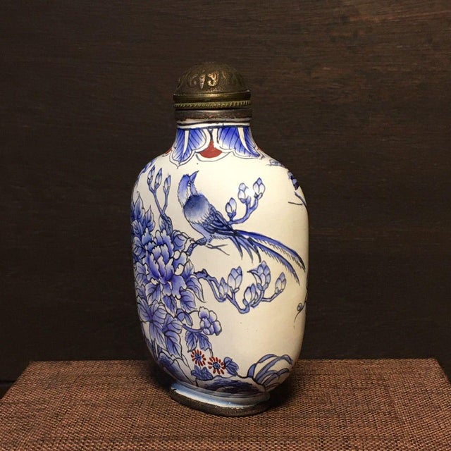 This is a charming vintage Chinese snuff bottle, crafted from copper with painted enamel decoration. The bottle features a...