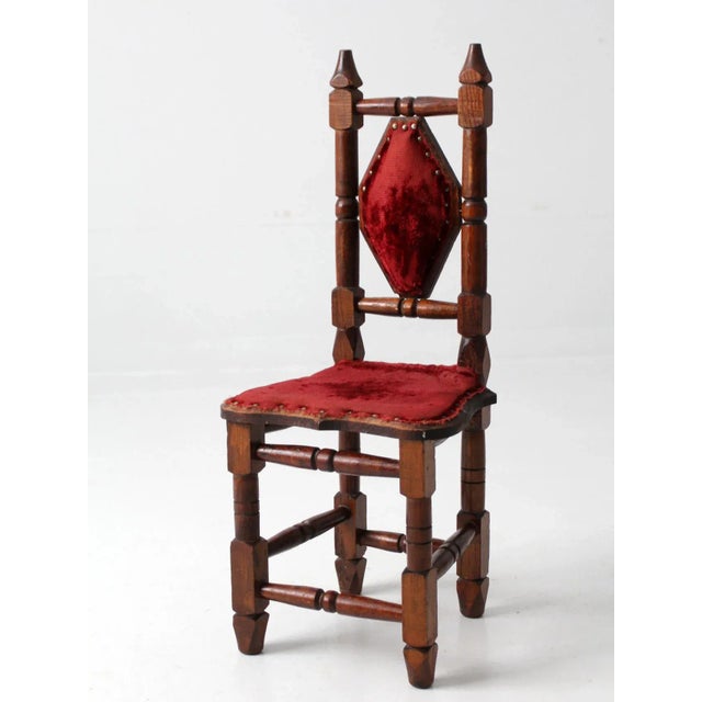 This is a mid 20th century Mexican hacienda children's chair. The gothic wooden chair features red velvet upholstered...