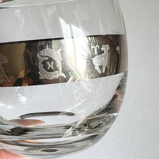 A set of four vintage mid-century modern silver banded roly poly glasses with astrological signs. This glass shape is...
