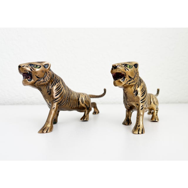 A stunning pair of solid brass tigers adorned with subtle hand painted stripes, green eyes, and red mouths. Showcases...