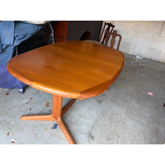 The 1960s 7 ft Danish Teak Oval Dining Table with a 20" Hide Away Center Leaf is a beautifully crafted piece of mid-...