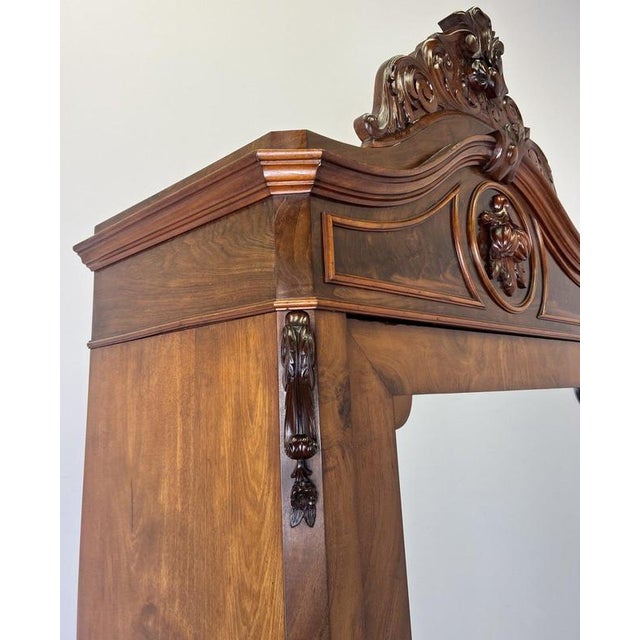 An impressive Antique French wardrobe in Walnut, showcasing rich burr figuring, a tall mirrored door and an elaborate...
