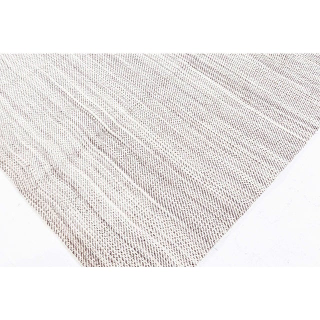 This contemporary flat weave runner exudes quiet elegance through its minimalist design and finely crafted structure....