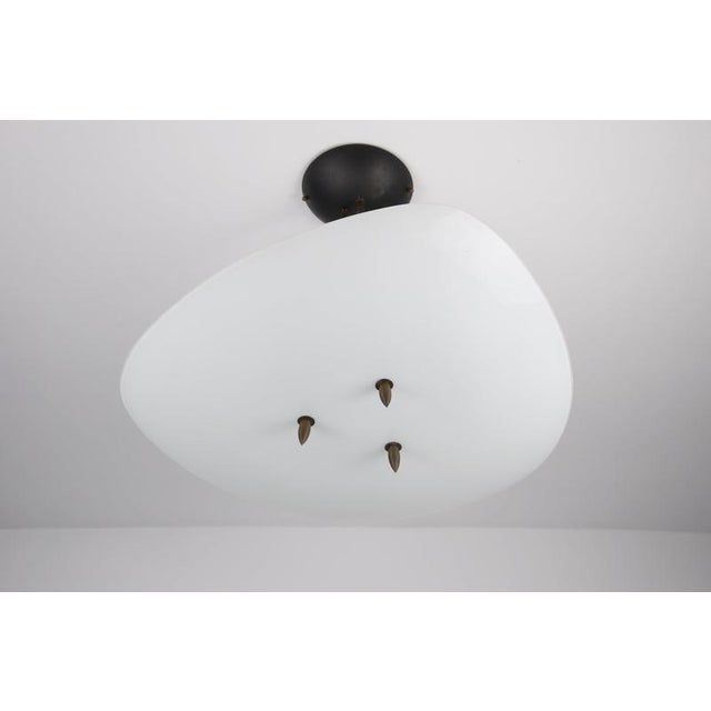 Italian mid-century pendant lamp from the 1960s, featuring an unusual combination of a large, softly curved white glass...