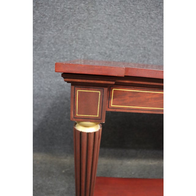 Mahogany console table by McLain Wiesand with satinwood-style inlay and fluted legs. Features a lower shelf and brass...