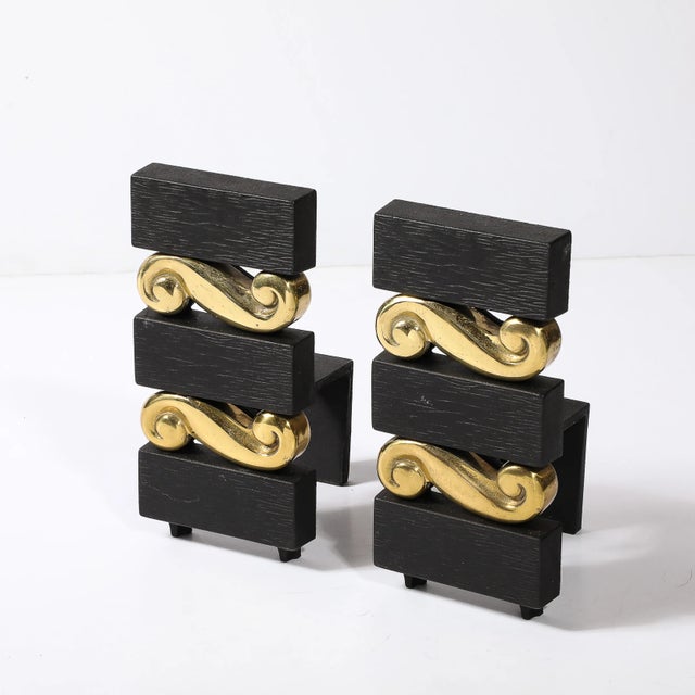 This unique and sophisticated Pair of Mid-Century Modernist Stacked Scroll form Andirons in Brass & Bronze W/ Faux Bois...