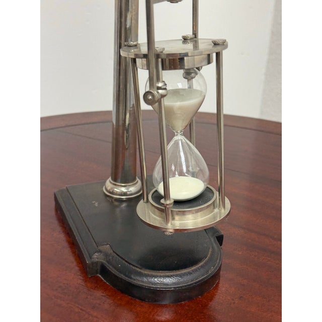 Design Plus Gallery presents a Vintage Brass Hourglass Timer on Wood Base. This decorative timer has a metal framed...