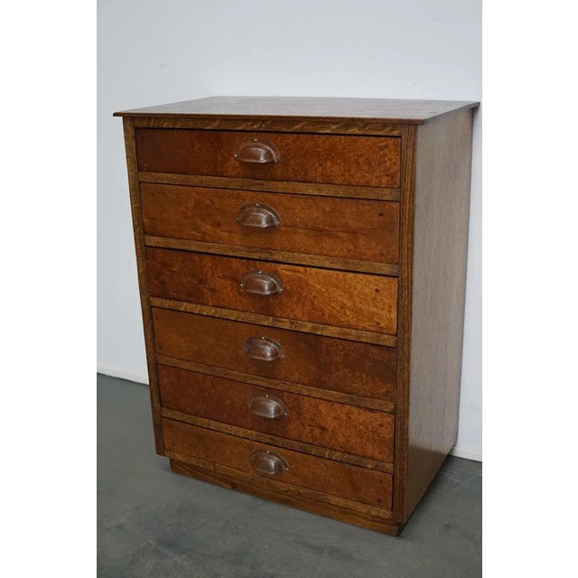 This apothecary cabinet was made circa 1950s in Germany. It features 6 drawers with metal cup handles. The frame and top...