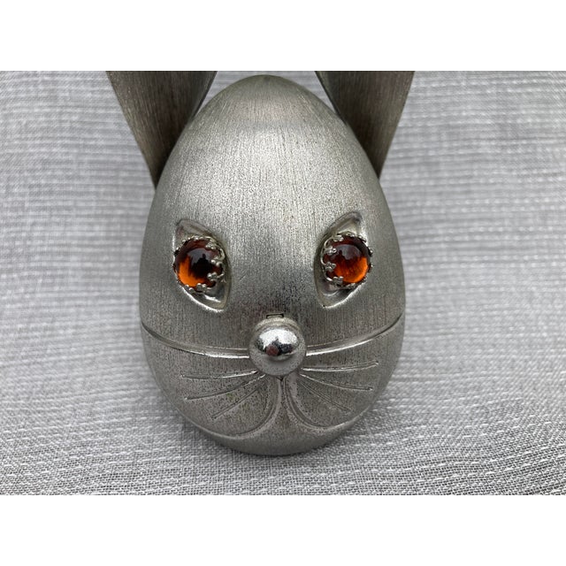 Mid Century brushed metal rabbit piggy bank with amber colored cabochon eyes and oversized ears. Marked Napier. Very good...