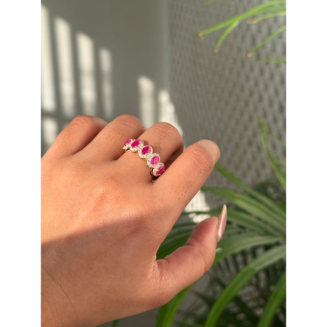This half band ring is features a 1.5 carat natural oval rubies in 14K yellow gold. and vibrant with a total stone weight...