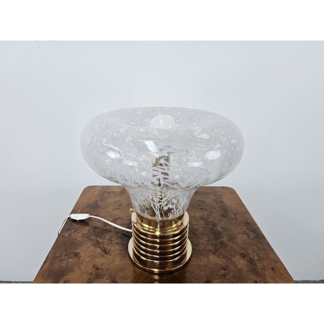 Beautiful 1970s table lamp in worked glass with golden metal base and exposed bulb. Perfect for enriching any vintage or...