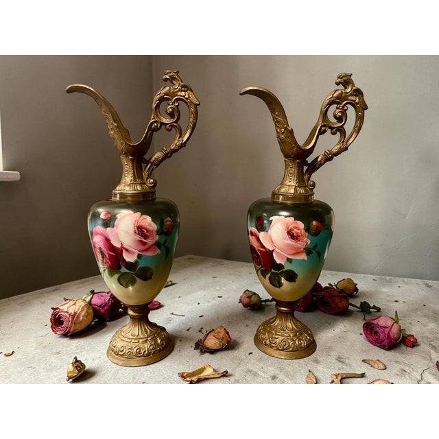 An exceptional pair of Austrian Victorian ewers dating to circa 1890–1910. These decorative vessels feature richly cast...