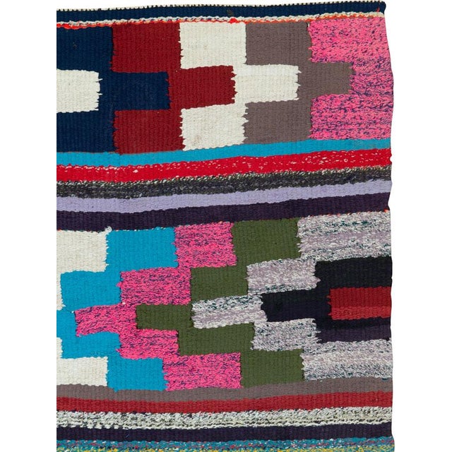 This mid-20th century Persian flatweave kilim rug is a spirited example of tribal weaving, alive with bold geometry and an...