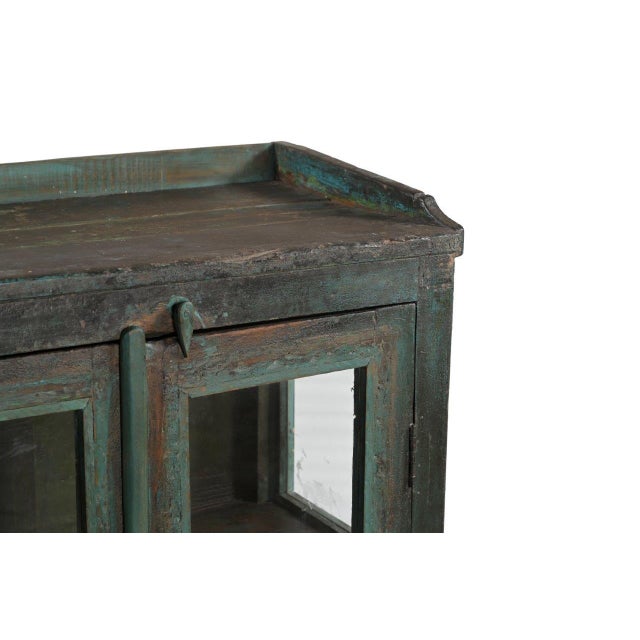 This Vintage Indian Painted Teakwood Small Bookcase is constructed from solid teakwood, retaining a beautifully aged green...