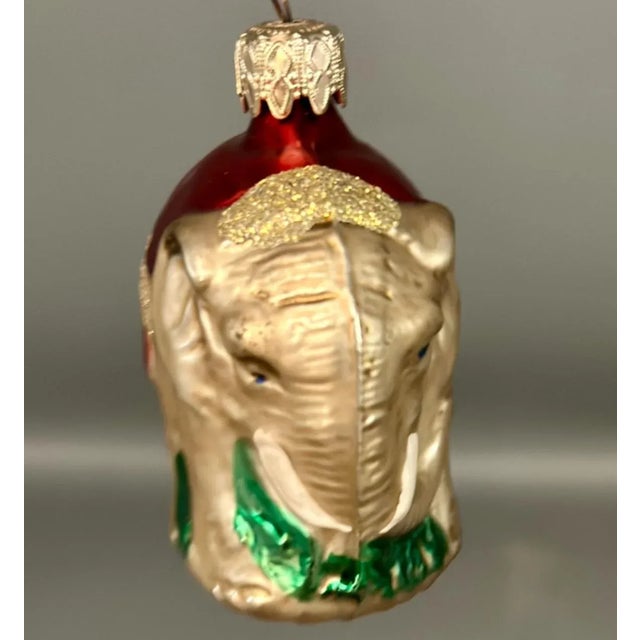 A 1920s German elephant glass ornament is a hand-blown, silvered glass figure shaped like a small elephant, often with...