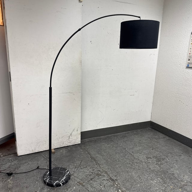 Design Plus Gallery presents the Arc Floor Lamp from EQ3. A sweeping arc rises from a round marble base and black stem,...